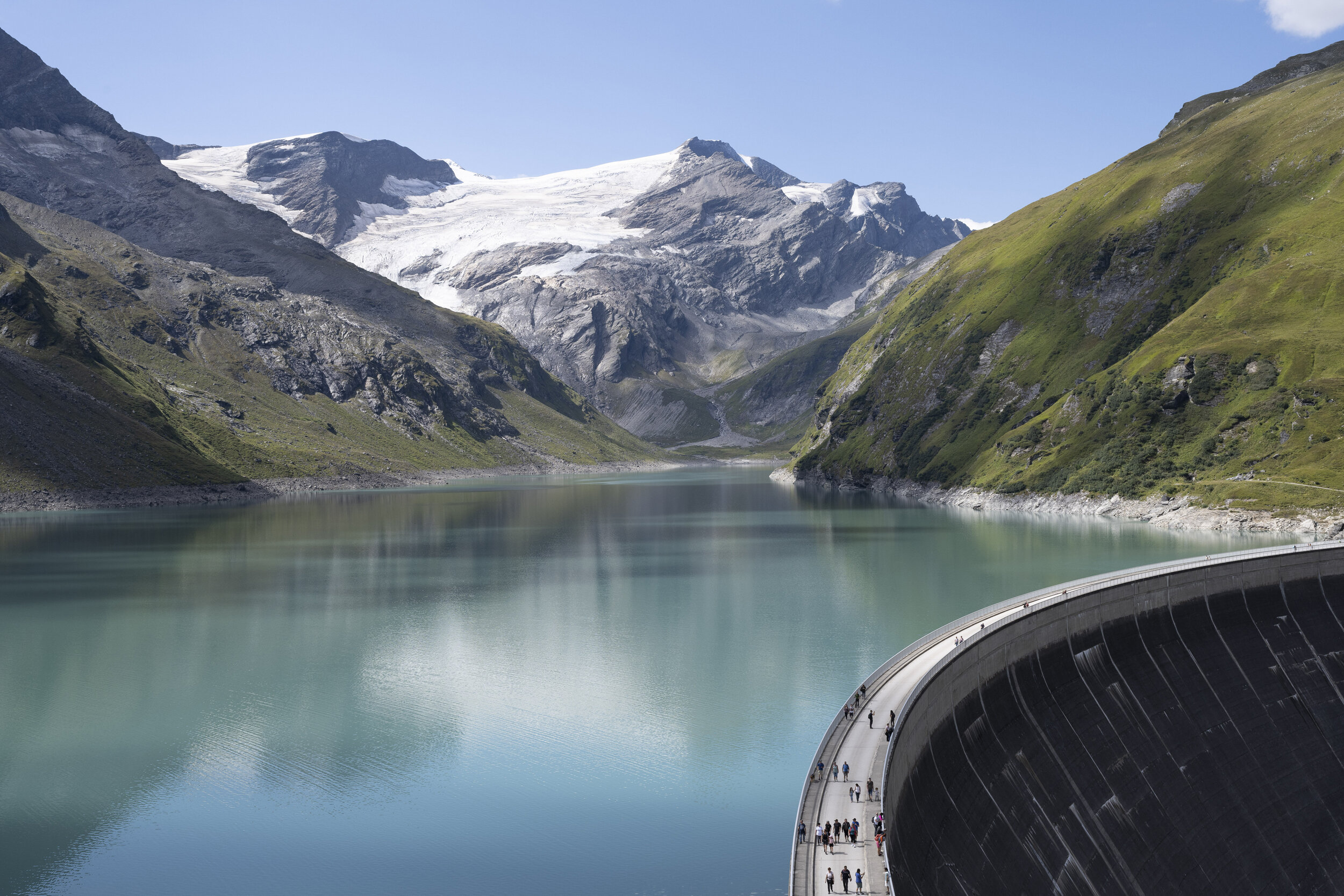 Ansicht des Stausees Kaprun mit der Staumauer in der Mitte, dahinter Stausee und die Berge | © VERBUND, Johannes Wiedl
