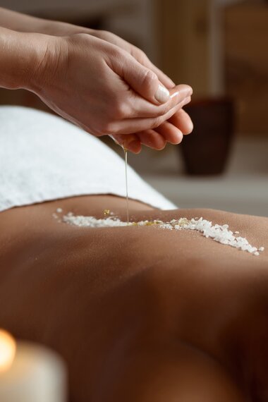 Junge Frau entspannt im Spa Salon, Öl und Salz wird auf ihren Rücken gegeben | © Freepik