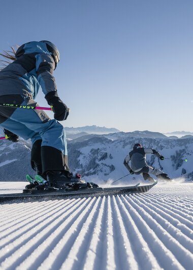 Skifahrer auf frisch präparierten Pisten in den Hochkönig-Bergen erleben Winterfreude pur. | © Hochkönig Tourismus GmbH