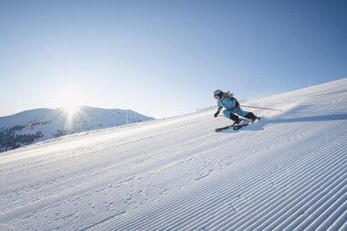Skifahrer genießt die verschneiten Hänge am Hochkönig unter strahlendem Sonnenschein.  | © Hochkönig Tourismus GmbH
