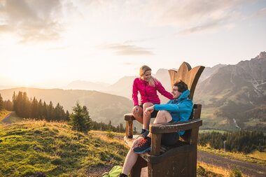 Zwei Wanderer genießen den Sonnenuntergang in den Bergen der Region Hochkönig, umgeben von Natur und Ruhe. | © Hochkönig Tourismus GmbH