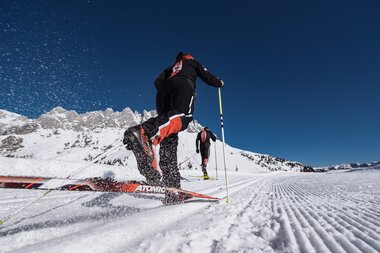 Ein Langläufer genießt die Winterlandschaft in der Region Hochkönig mit schneebedeckten Bergen und blauem Himmel. | © Hochkönig Tourismus GmbH