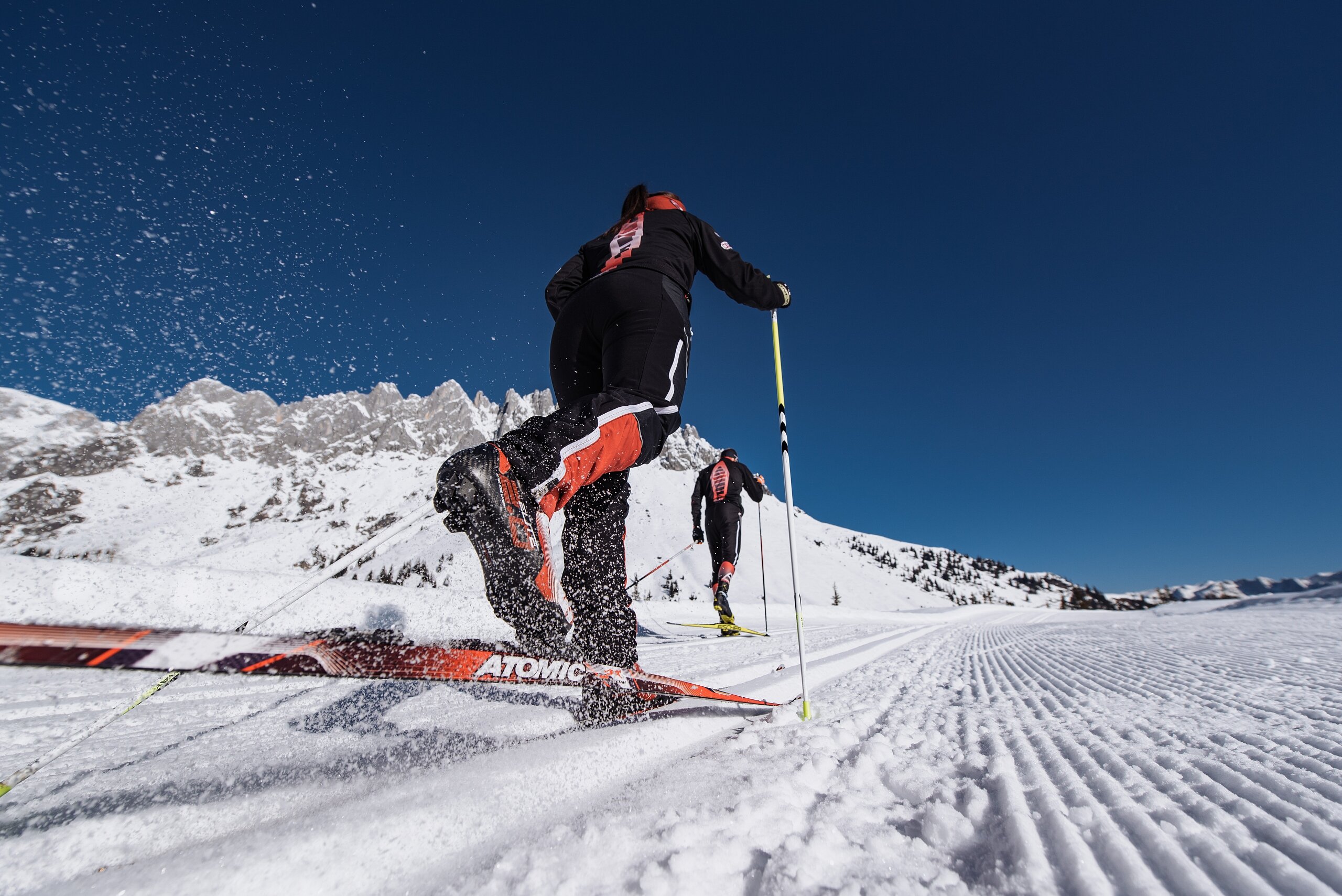 Ein Langläufer genießt die Winterlandschaft in der Region Hochkönig mit schneebedeckten Bergen und blauem Himmel. | © Hochkönig Tourismus GmbH