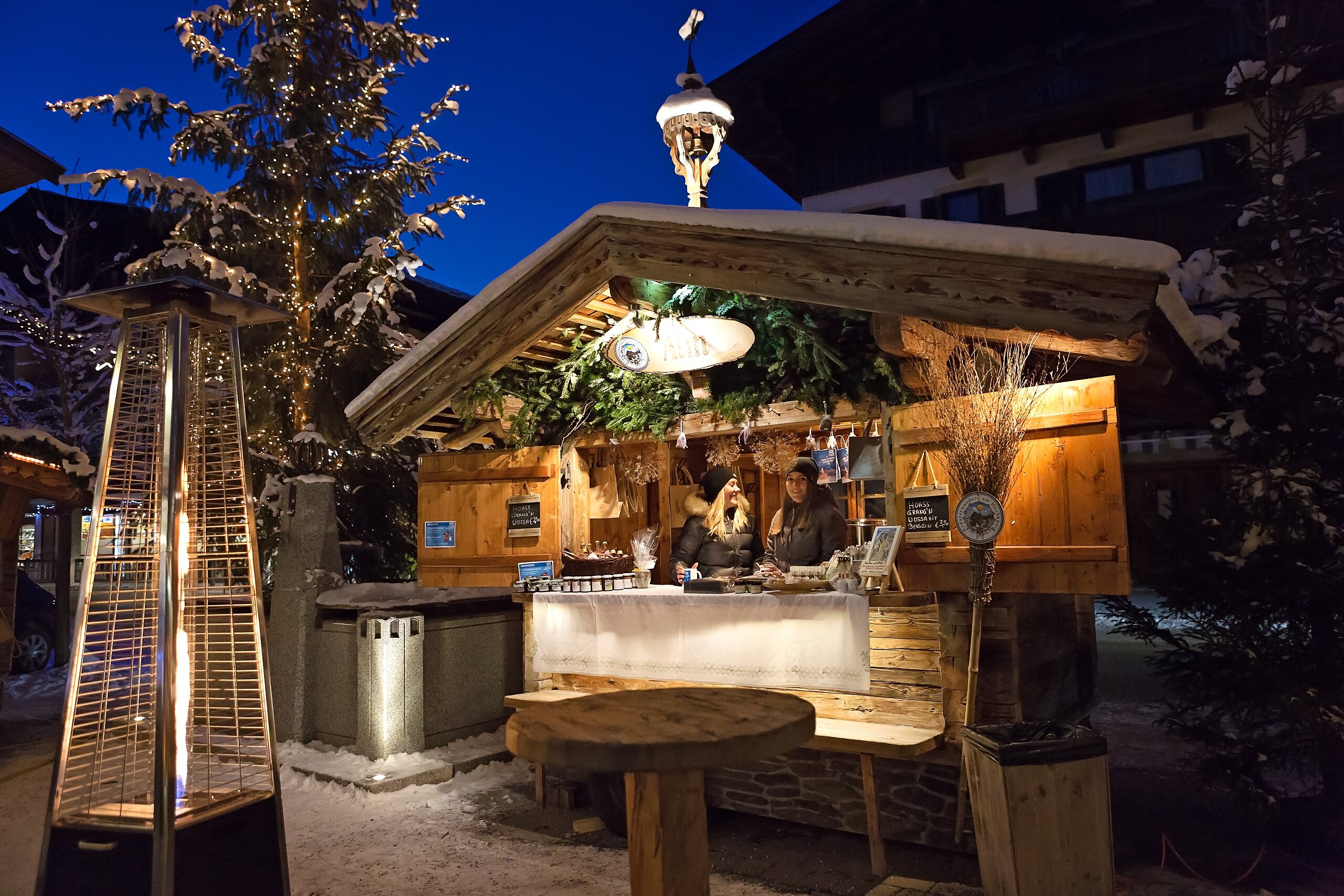 Eine beleuchtete Holzhütte beim Wintermarkt am Hochkönig bei Nacht, einladend und stimmungsvoll in winterlicher Umgebung. | © Hochkönig Tourismus GmbH