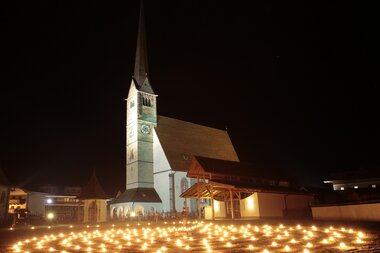 Stimmungsvolle Kirche in der Region Hochkönig, umgeben von Laternen. | © Hochkönig Tourismus GmbH