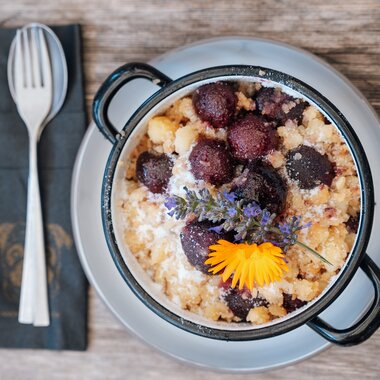 Regionaler Genuss mit Kaiserschmarrn und Beeren auf rustikalem Holztisch im Hochkönig.  | © Hochkönig Tourismus GmbH