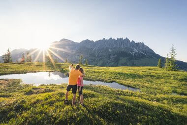 Zwei Wanderer bei Sonnenuntergang in den Bergen der Hochkönigregion, umgeben von Natur und Ruhe. | © Hochkönig Tourismus GmbH