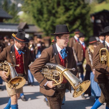 Eine traditionelle Kapelle spielt in den Bergen von Hochkönig. Die Musiker tragen Trachten und verbreiten Freude in der schönen Alpenlandschaft. | © Hochkönig Tourismus GmbH