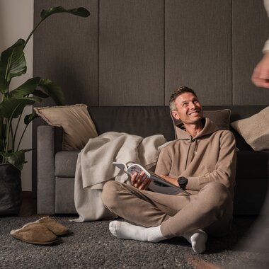 Ein Mann sitzt am Boden und liest eine Zeitschrift | © Karin Pasterer