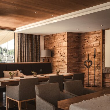 Sunnsait Lounge with tables, chairs, and fireplaces | © Karin Pasterer